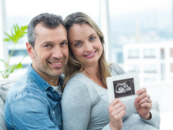 couple holding ultrasound confirming pregnancy