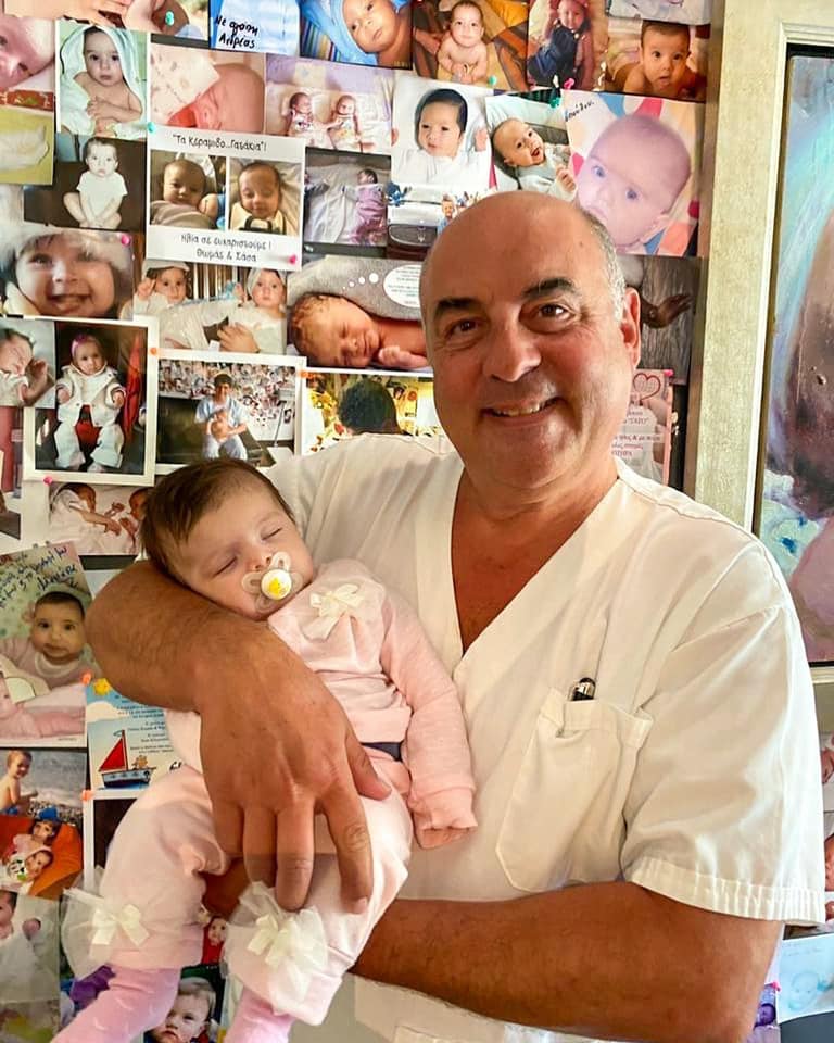 dr. thanos paraschos holding one of the many babies born with IVF in Embio clinic