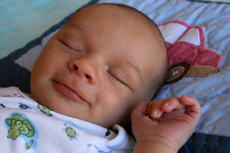 babydreng der sover og smiler