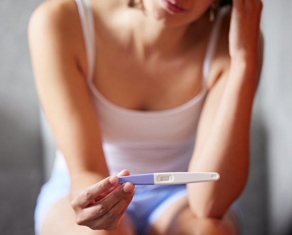 žena drži test za trudnoću