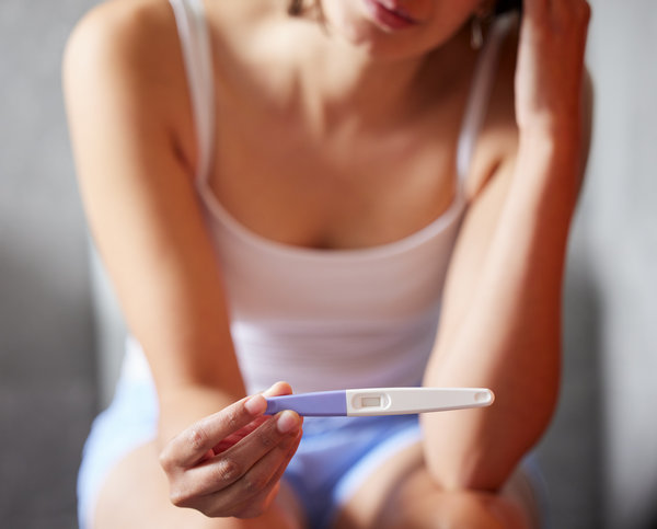 woman holding a pregnancy test